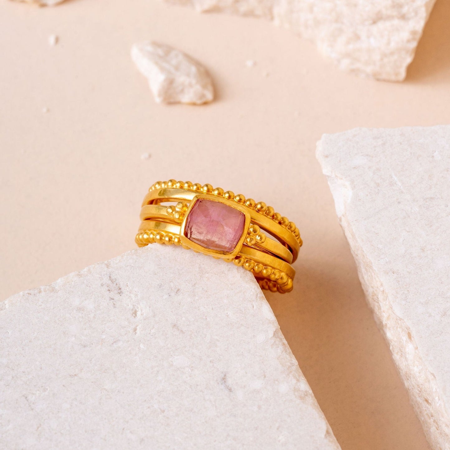 Handcrafted gold ring with delicate granulation and a small light pink square tourmaline gemstone.
