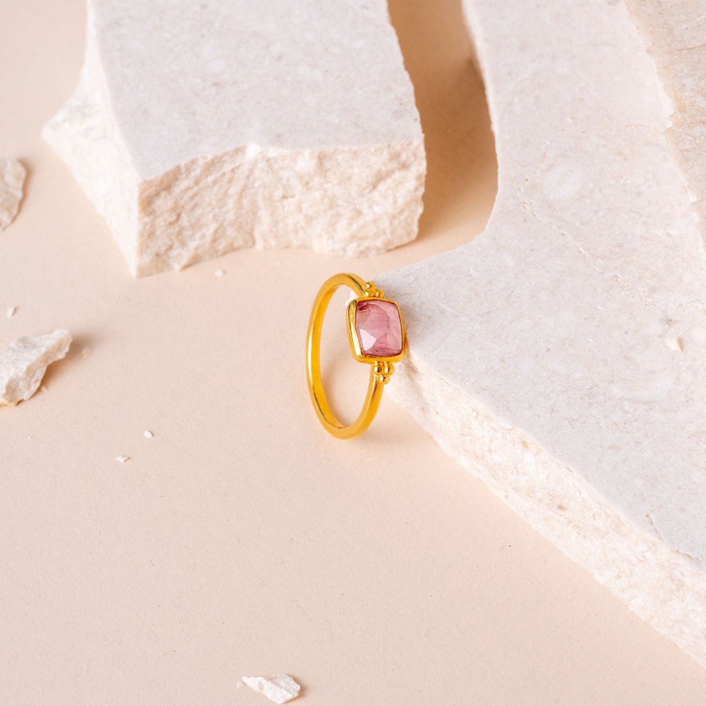 Delicate gold ring with intricate granulation, showcasing a small hand-cut light pink tourmaline.