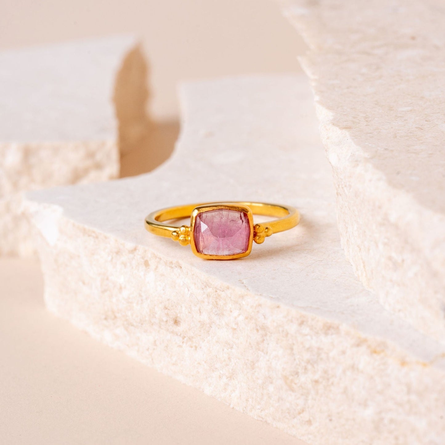 Rich gold ring with intricate granulation, featuring a small hand-cut light pink tourmaline